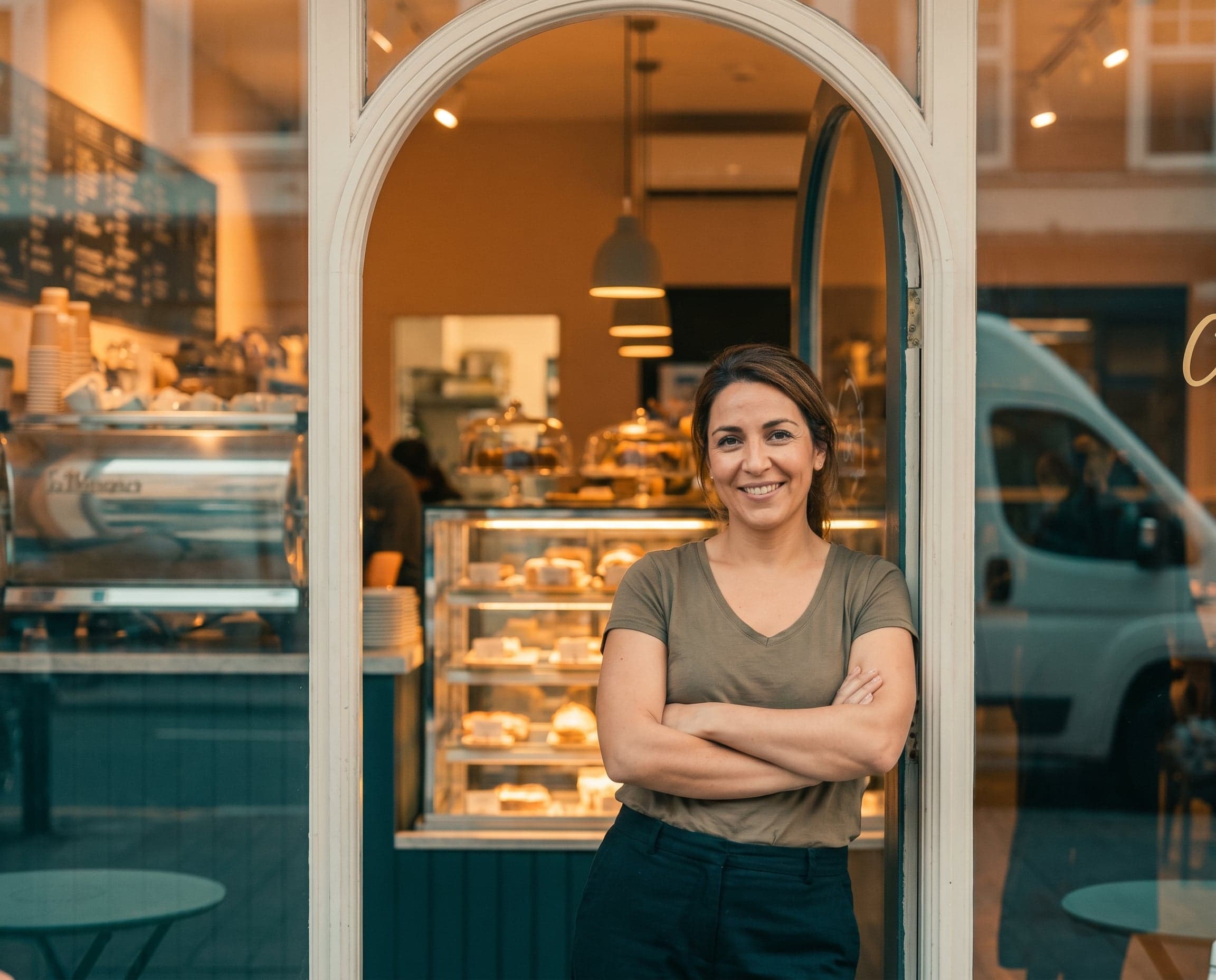 The owner of a bakery, standing in the doorway of her shop